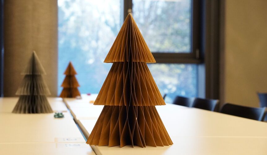 Weihnachtsbäume aus Papier schmücken die Tische im Seminarraum.