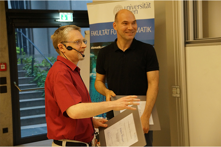 Dekan Gansterer überreicht Professor Zdun eine Urkunde. 